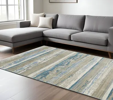 8' X 11' Ivory Beige Grey Blue And Tan Abstract Power Loom Stain Resistant Area Rug With Fringe