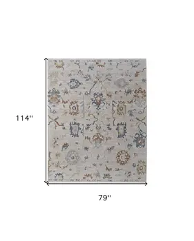 7' X 10' Ivory Blue and Gold Floral Power Loom Worn Faded Area Rug With Fringe