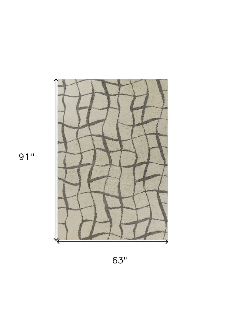 5' X 7' Ivory Machine Woven Abstract Indoor Shag Rug