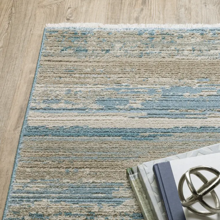 4' X 6' Ivory Beige Grey Blue And Tan Abstract Power Loom Stain Resistant Area Rug With Fringe