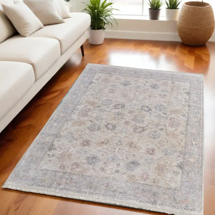 5' X 8' Ivory Tan and Blue Floral Hand Woven Distressed Area Rug With Fringe