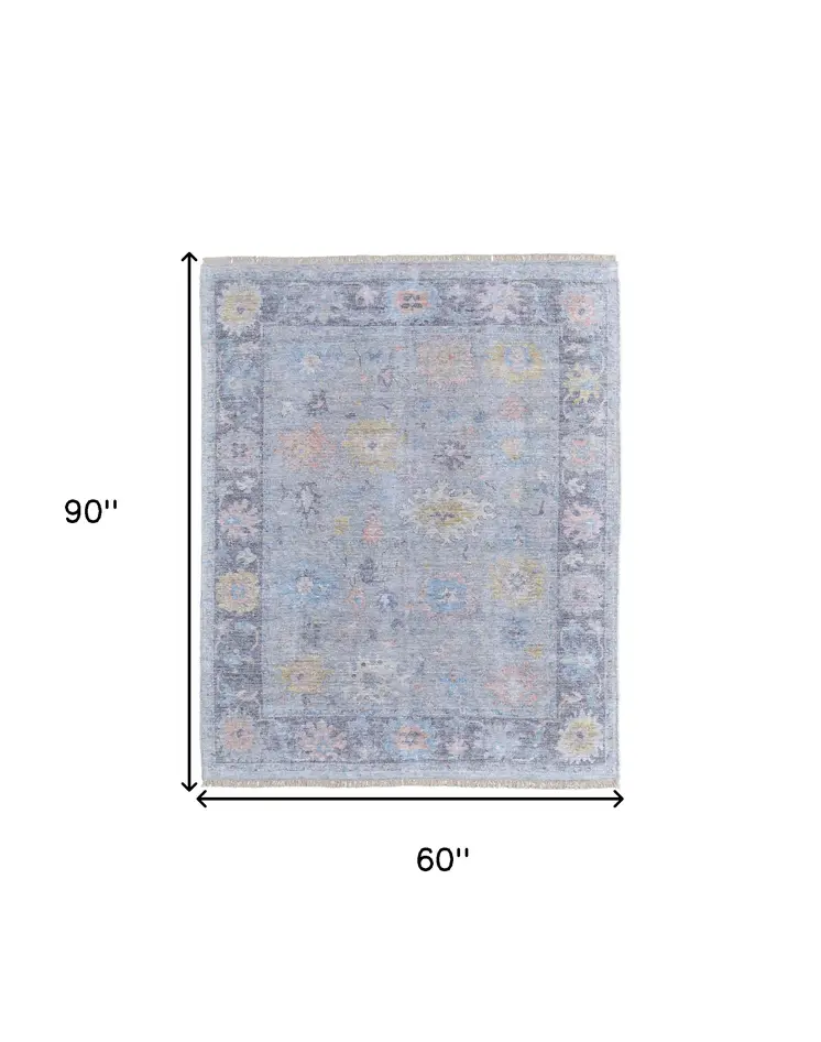 5' X 8' Orange Blue and Gold Floral Hand Woven Distressed Area Rug With Fringe